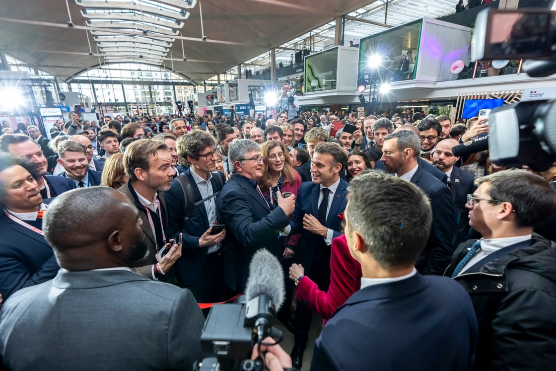 Emmanuel Macron surrounded by a crowd at the AI Action Summit